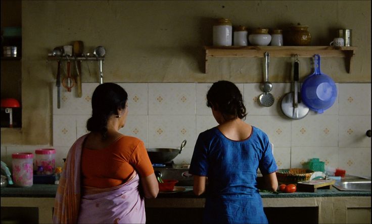 Behind view of two women cooking side by side
