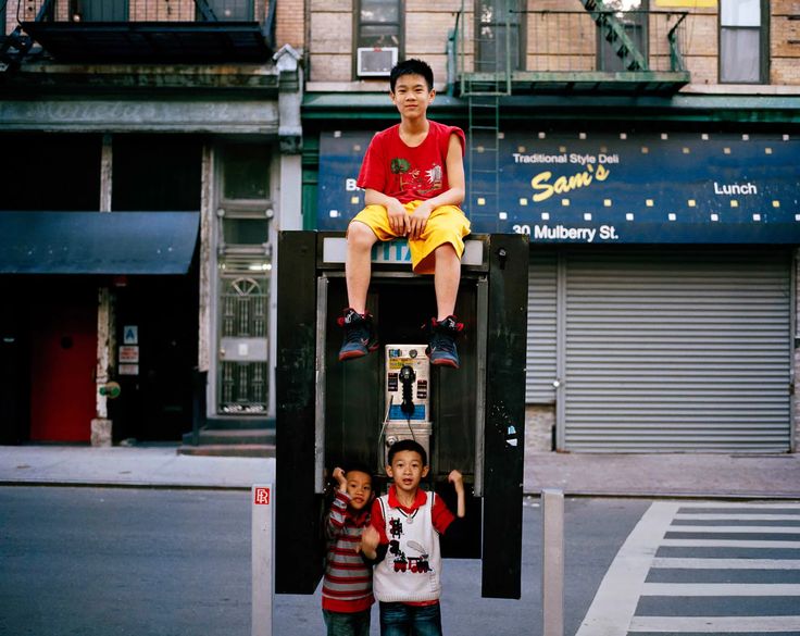 Children hanging out around a phone booth