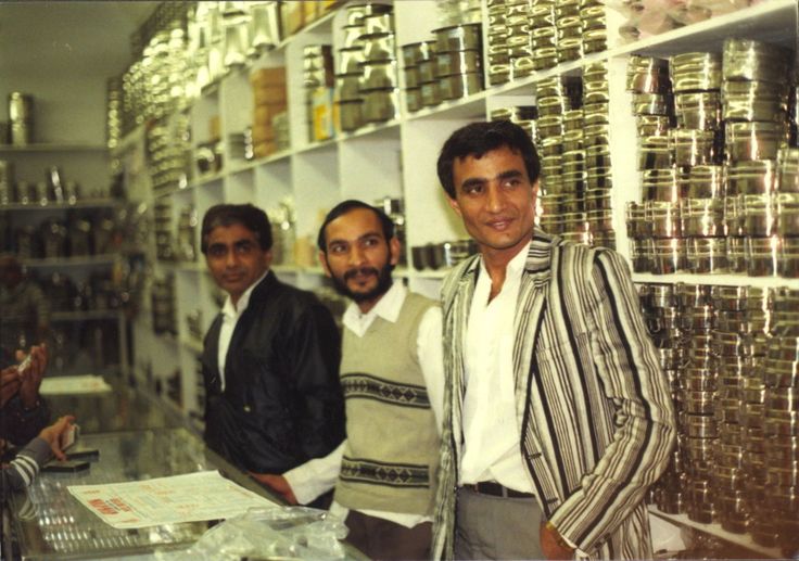An old photo of three men standing in a grocery store